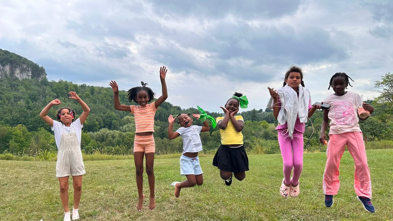 Young people of the nation leaping in a field.